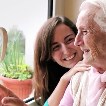 private carer with old lady by window