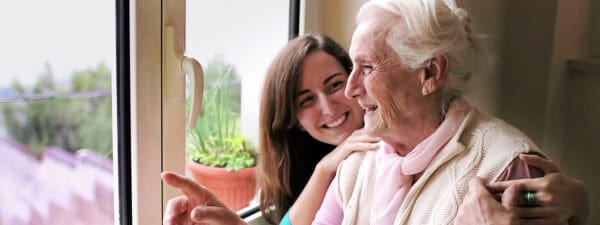 private carer with old lady by window