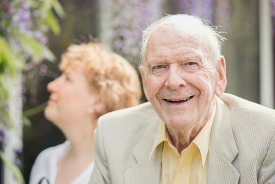 Elderly man with his daughter in garden