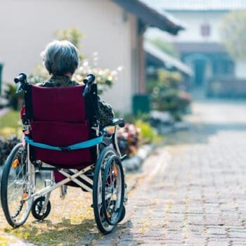 old lady in wheelchair in garden of sheltered accommodation